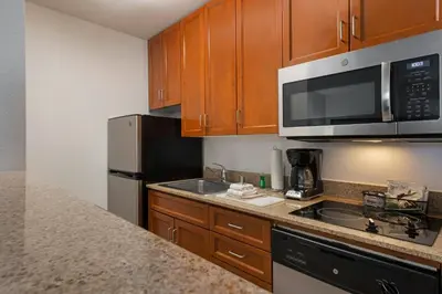 a kitchen with wooden cabinets and stainless steel appliances at TownePlace Suites by Marriott Ontario Airport in Rancho Cucamonga
