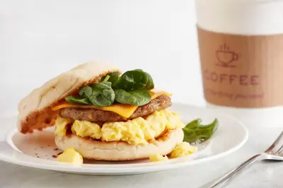 a breakfast sandwich on a plate next to a cup of coffee at Residence Inn by Marriott Ontario Airport in Ontario