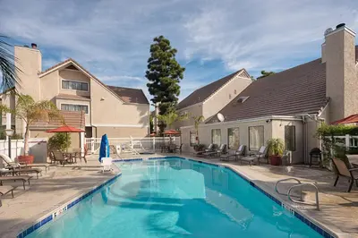 a swimming pool in front of a house at Residence Inn by Marriott Ontario Airport in Ontario