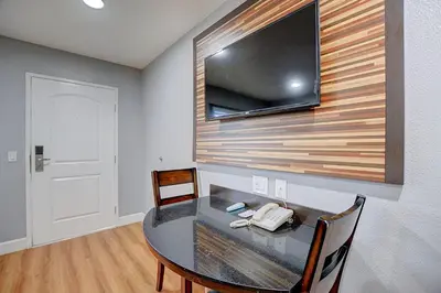 a room with a table and a television on a wall at Welcome Inn San Bernardino/ Colton in Colton