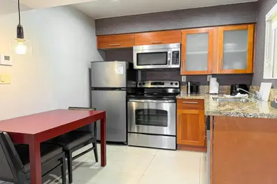 a kitchen with stainless steel appliances and a red table at Residence Inn La Mirada Buena Park in La Mirada