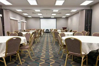 a room with tables and chairs and a whiteboard at Residence Inn La Mirada Buena Park in La Mirada