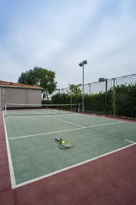 a tennis racket and ball on a tennis court at Residence Inn La Mirada Buena Park in La Mirada