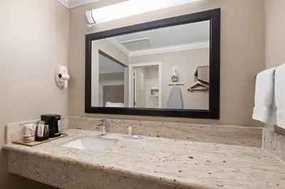 a bathroom with a sink and a large mirror at Solara Inn and Suites in Anaheim