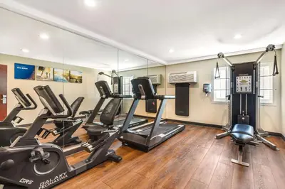 a gym with treadmills and ellipticals in front of a mirror at Comfort Inn Monterey Park - Los Angeles in Monterey Park