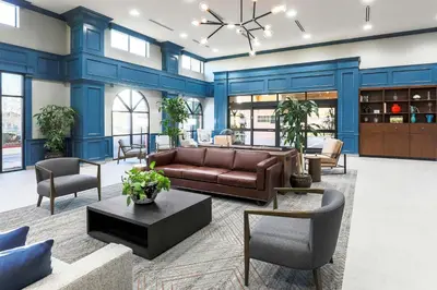 a living room with blue walls and a couch and chairs at Four Points by Sheraton, Ontario-Rancho Cucamonga in Rancho Cucamonga