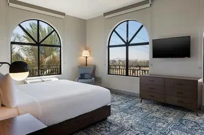 a bedroom with a bed and a tv and two windows at Four Points by Sheraton, Ontario-Rancho Cucamonga in Rancho Cucamonga