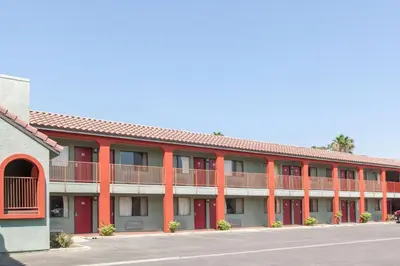 a large red building with a street in front at America's Best Value Inn & Suites Bakersfield Central in Bakersfield