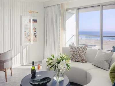a living room with a white couch and a view of the beach at Regent Santa Monica Beach in Los Angeles