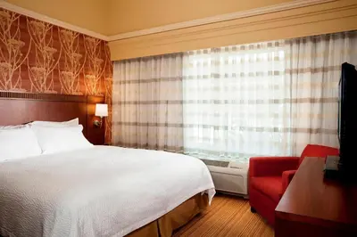 a hotel room with a bed and a red couch at Courtyard Ventura Simi Valley in Simi Valley