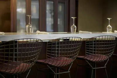 a table with three chairs and two vases at Courtyard Ventura Simi Valley in Simi Valley