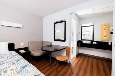 a room with a bed and a desk and a table at Motel 6 Ontario, CA - Airport in Ontario