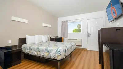 a small bedroom with a bed and a window at Motel 6 Ontario, CA - Airport in Ontario