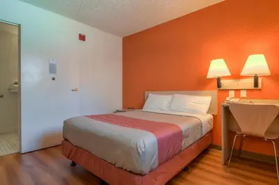 a hotel room with a bed and a desk with a table at Motel 6-Rowland Heights, CA - Los Angeles - Pomona in Rowland Heights