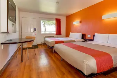 a hotel room with two beds and a table at Motel 6-Riverside, CA - South in Riverside