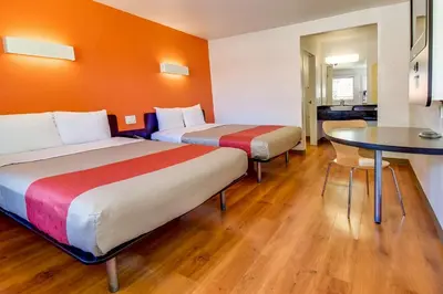 a hotel room with two beds and a table at Motel 6-Riverside, CA - South in Riverside