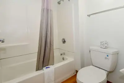 a white bathroom with a toilet and a bath tub at Motel 6-Riverside, CA - South in Riverside