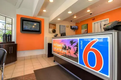 a large television in a room with an orange wall at Motel 6-San Dimas, CA - Los Angeles in San Dimas