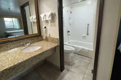 a bathroom with a sink and a toilet and a mirror at Quality Inn Ontario Airport Convention Center in Ontario