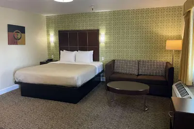 a hotel room with a bed and a chair at Quality Inn Ontario Airport Convention Center in Ontario