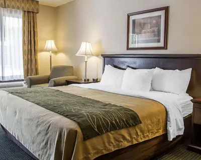 a hotel room with a large bed and a chair at Quality Inn Riverside near UCR and Downtown in Riverside