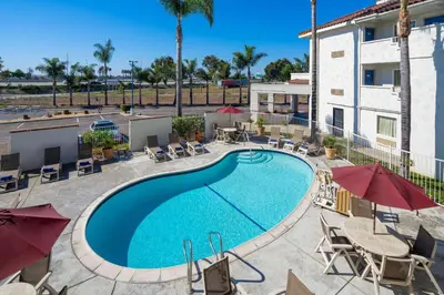 a swimming pool with chairs and umbrellas at a hotel at Motel 6-Ventura, CA - South in Ventura