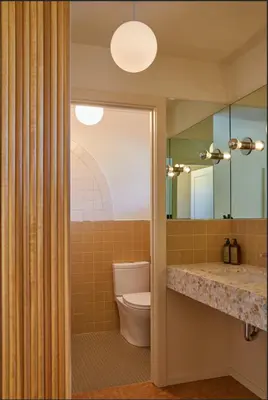 a bathroom with a toilet and a large mirror at The Capri Hotel in Ojai