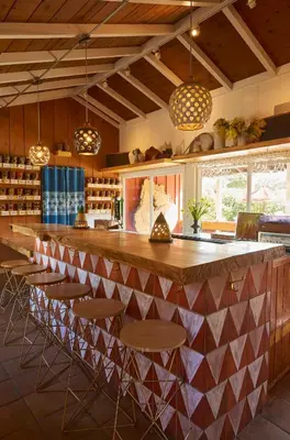 a kitchen with a bar with chairs and lights at Ojai Rancho Inn in Ojai