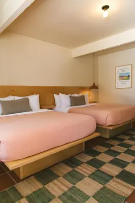two beds in a room with a checkered floor at Hummingbird Inn in Ojai