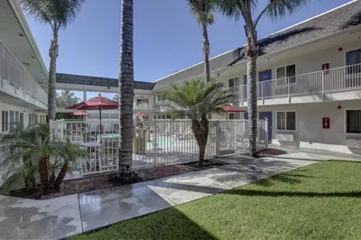 a courtyard with palm trees in front of a building at Motel 6-Westminster, CA - North in Westminster
