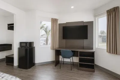 a room with a desk and a television on a wall at Motel 6-Westminster, CA - North in Westminster