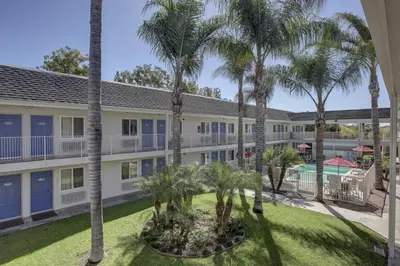 an exterior view of a building with palm trees at Motel 6-Westminster, CA - North in Westminster