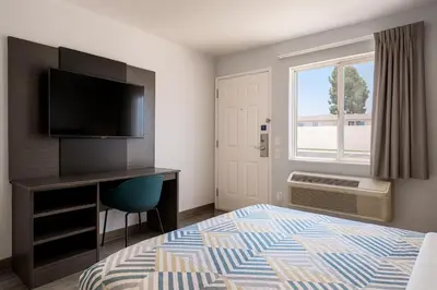 a hotel room with a bed and a desk with a television at Motel 6-Westminster, CA - North in Westminster