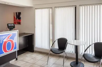 a room with chairs and a table and a tv at Motel 6 Bakersfield, CA - Convention Center in Bakersfield
