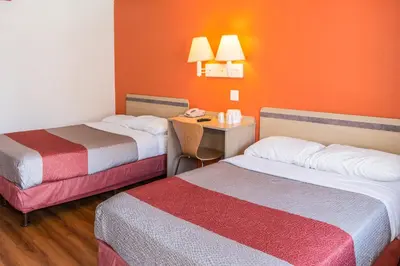 a hotel room with two beds and a desk at Motel 6 Bakersfield, CA - Convention Center in Bakersfield