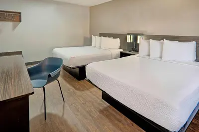 a hotel room with two beds and a blue chair at Motel 6-Lancaster, CA in Lancaster