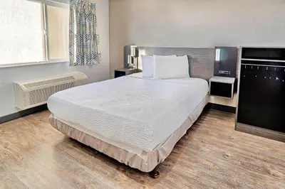 a bedroom with a large bed and a flat screen tv at Motel 6-Lancaster, CA in Lancaster