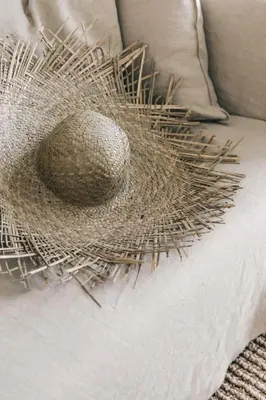 a wicker sculpture on a couch with a pillow at The Surfrider Malibu in Malibu