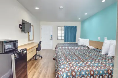 a hotel room with two beds and a television at Vagabond Inn Buttonwillow North I-5 in Buttonwillow
