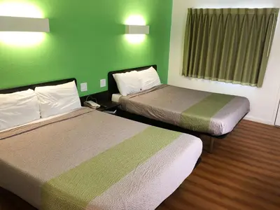 two beds in a hotel room with green walls at Motel 6-Barstow, CA in Barstow