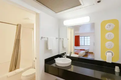 a bathroom with a sink and a toilet and a bedroom at Motel 6-Thousand Oaks, CA in Thousand Oaks