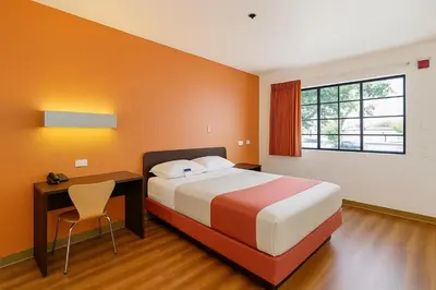 a bedroom with a bed and a desk and a bed and a window at Motel 6-Thousand Oaks, CA in Thousand Oaks