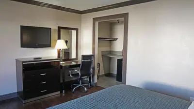 a hotel room with a bed and a desk and a television at Hawthorne Plaza Inn Near LAX in Hawthorne