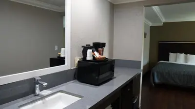 a hotel room bathroom with a sink and a bed at Hawthorne Plaza Inn Near LAX in Hawthorne