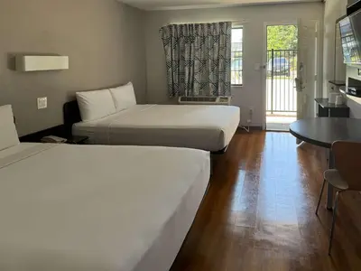 a room with two beds and a table and a kitchen at Motel 6-Pomona, CA - Los Angeles in Pomona