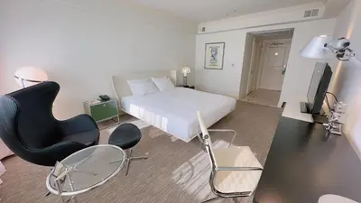 a bedroom with a bed and a desk and a chair at Oxford Palace Hotel in Los Angeles