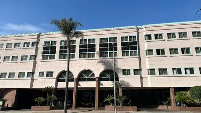 a building with a palm tree in front of it at Oxford Palace Hotel in Los Angeles