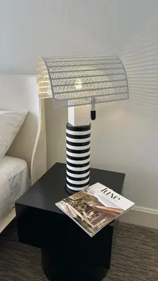 a table with a lamp and a magazine on it at Oxford Palace Hotel in Los Angeles