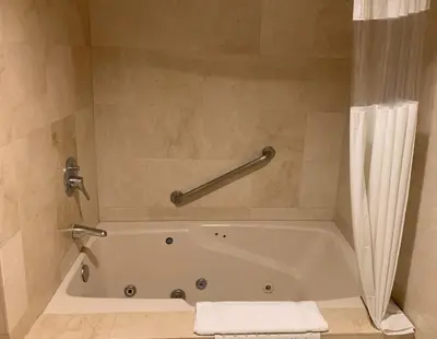 a bathroom with a bath tub with a shower curtain at Oxford Palace Hotel in Los Angeles