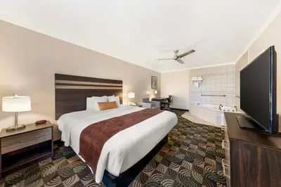 a hotel room with a bed and a flat screen tv at Best Western Plus Country Park Hotel in Tehachapi